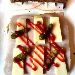 Tartine garnie de fromage, cornichons et sauce Sriracha
